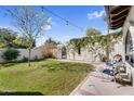 The grassy backyard has manicured landscaping, mature trees, and a white stucco wall at 718 E Tuckey Ln, Phoenix, AZ 85014