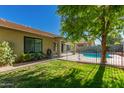 Beautiful backyard with a swimming pool, grass, and a covered patio at 9212 W Salter Dr, Peoria, AZ 85382