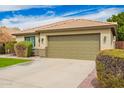 A tan single-story home featuring a well-maintained two-car garage and desert landscaping at 9212 W Salter Dr, Peoria, AZ 85382