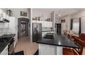 Open kitchen featuring stainless appliances, a breakfast bar, and seamless flow to living area at 9212 W Salter Dr, Peoria, AZ 85382