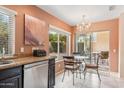 Eat-in kitchen area featuring a dining table, chandelier, and backyard views at 9445 N 106Th St, Scottsdale, AZ 85258