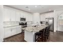 Bright kitchen with white cabinets, granite countertops, stainless steel appliances, and center island at 9823 E Red Giant Dr, Mesa, AZ 85212