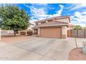 Charming home with a wide driveway, lush landscaping, and an attached two-car garage at 11023 E Florian Ave, Mesa, AZ 85208