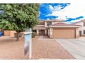 Inviting two-story home featuring a well-maintained front yard, sign, and a 2-car garage at 11023 E Florian Ave, Mesa, AZ 85208