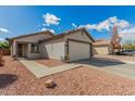 Cozy home showcasing a well-kept front yard and convenient two-car garage at 11813 W Sierra St, El Mirage, AZ 85335