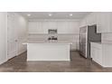 Well-lit kitchen boasts white cabinetry, quartz countertops, stainless appliances, and wood-look tile floors at 12378 W Marguerite Ave, Avondale, AZ 85323