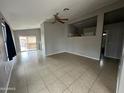Bright living room featuring tile flooring, neutral paint, and sliding glass doors to the backyard patio at 15023 W Caribbean Ln, Surprise, AZ 85379
