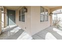 Covered front porch featuring an arched entryway and view of the beautiful green front door at 15469 W Dreyfus St, Surprise, AZ 85379