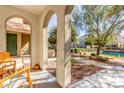 Inviting covered porch with arched supports overlooking a landscaped community park and walking path at 1723 E Hampton Ln, Gilbert, AZ 85295