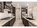 Modern kitchen featuring granite countertops, tile backsplash, and stainless steel appliances at 1933 N 140Th Ave, Goodyear, AZ 85395