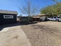 Gravel driveway featuring advertising signage and a vehicle parked on the right at 2205 W Hadley St, Phoenix, AZ 85009