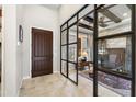 Home office showcasing stone accent wall, dark wood built-ins, black desk and black framed glass doors at 22410 N 29Th Pl, Phoenix, AZ 85050