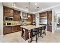 Gourmet kitchen featuring a large island with seating, stainless steel appliances, custom cabinets, and tile backsplash at 22410 N 29Th Pl, Phoenix, AZ 85050