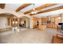 Open-concept living space featuring exposed wood beams, tile floors, and an archway leading to the kitchen at 28619 N 152Nd St, Scottsdale, AZ 85262