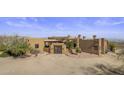 Exterior view of a luxurious estate with desert landscaping and mountain views at 31912 N 141St St, Scottsdale, AZ 85262