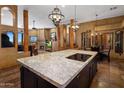 Open-concept kitchen with granite island, breakfast bar, and seamless flow to the living area at 31912 N 141St St, Scottsdale, AZ 85262