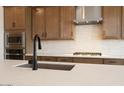 Close-up of the kitchen island featuring quartz countertops, a sink, and stainless appliances at 40234 N Alegre Dr, San Tan Valley, AZ 85140