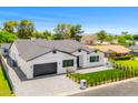 A charming exterior showcasing a well-manicured lawn, a black garage door, and tasteful landscaping at 4115 E Windsor Ave, Phoenix, AZ 85008