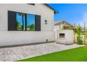 A lovely outdoor patio area featuring a modern fireplace, gray brickwork, and well-maintained artificial turf at 4115 E Windsor Ave, Phoenix, AZ 85008
