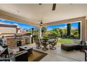 Covered patio featuring an outdoor kitchen, dining set, and cozy seating area at 4459 E Donato Dr, Gilbert, AZ 85298