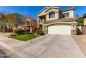 Charming two-story home with a well-manicured front lawn, driveway, two-car garage and tiled roof at 5234 E Carol Ave, Mesa, AZ 85206