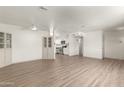 Open-concept living room with new flooring, light walls, and access to kitchen at 5732 E Covina Rd, Mesa, AZ 85205