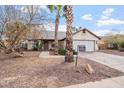 Inviting one-story home with xeriscaping, palm trees, and a two-car garage at 723 E Piute Ave, Phoenix, AZ 85024