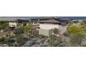 A modern home's exterior is accented by desert landscaping, providing a natural and sustainable design at 8395 E Leaning Rock Rd # 187, Scottsdale, AZ 85266