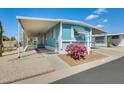 Inviting blue home featuring a carport, desert landscaping, and eye-catching magenta cactus in the front yard at 8600 E Broadway Rd # 28, Mesa, AZ 85208