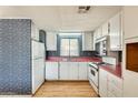 Bright kitchen with white cabinetry, appliances, a pink countertop, and a window bringing natural light into the space at 8600 E Broadway Rd # 28, Mesa, AZ 85208