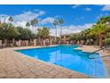 Sparkling community swimming pool surrounded by lush landscaping and lounge chairs at 10030 W Indian School Rd # 226, Phoenix, AZ 85037