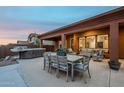 Covered patio area with an outdoor dining table, lounge seating, and a hot tub at 10672 N 140Th Way, Scottsdale, AZ 85259