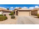 Inviting one-story home showcases a two-car garage, desert landscaping, and a tile roof at 1100 E Vernoa St, San Tan Valley, AZ 85140