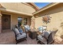 Inviting outdoor patio with comfortable seating and a stylish sunburst wall decoration at 12320 W Lone Tree Trl, Peoria, AZ 85383