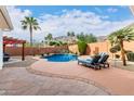 Inviting backyard pool area with a spa, lounge chairs, lush landscaping, and an outdoor entertainment area at 1356 E Desert Flower Ln, Phoenix, AZ 85048