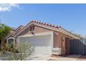 Charming single-story home featuring a well-maintained front yard, two-car garage, and a terracotta-tiled roof at 1422 S 231St Ln, Buckeye, AZ 85326