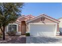 Charming single-story home featuring a well-maintained front yard, two-car garage, and a terracotta-tiled roof at 1422 S 231St Ln, Buckeye, AZ 85326