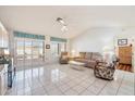 Bright living room with tiled floors, large windows, and a cozy seating arrangement at 14710 W Yosemite Dr, Sun City West, AZ 85375