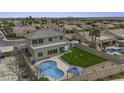 Aerial view of a backyard featuring a pool, lawn, privacy fence and covered patio area at 16606 S 15Th Ln, Phoenix, AZ 85045