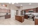 Spacious kitchen features stainless steel appliances, an island, and dark cabinets at 17574 W Corrine Dr, Surprise, AZ 85388