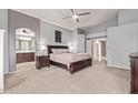 Comfortable main bedroom with ensuite bathroom, neutral tones, and a ceiling fan at 17574 W Corrine Dr, Surprise, AZ 85388