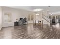 Spacious living area featuring wood floors, multiple windows for natural light, and staircase to the second floor at 18537 W Mariposa Dr, Surprise, AZ 85374