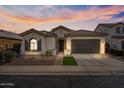 Charming single-story home featuring a two-car garage, desert landscaping and cozy facade under a vibrant sunset at 1855 E Crescent Way, Chandler, AZ 85249