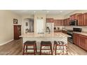 Modern kitchen boasts a large center island with seating, stainless steel appliances, and wood flooring at 21362 N 260Th Ln, Buckeye, AZ 85396