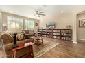 Inviting living room with a ceiling fan, wood floors, and a large bookcase at 21362 N 260Th Ln, Buckeye, AZ 85396