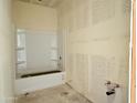 Unfinished bathroom featuring a white bathtub with shelving, awaiting final fixtures and finishes at 2401 E Spur Dr, San Tan Valley, AZ 85140