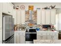 Charming kitchen featuring white cabinetry, brick backsplash, stainless appliances, and farmhouse-style decor at 28404 N 67Th St, Cave Creek, AZ 85331