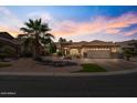 Attractive single-story home with a desert landscape, palm trees and a blue sky at 4068 N 155Th Ln, Goodyear, AZ 85395