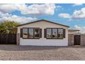 The house has many windows with black shutters, gravel landscaping, and privacy fencing at 525 S 99Th St, Mesa, AZ 85208