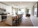 Bright kitchen featuring a breakfast bar with stylish seating, stainless steel appliances, and an open layout leading to living area at 624 N Vine St, Chandler, AZ 85225